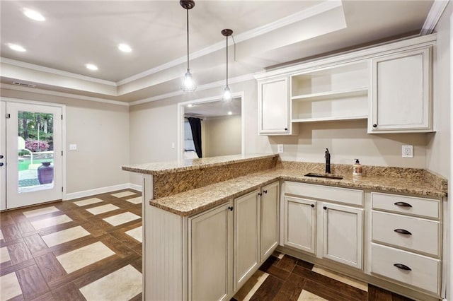 kitchen with a tray ceiling, a sink, a peninsula, baseboards, and recessed lighting