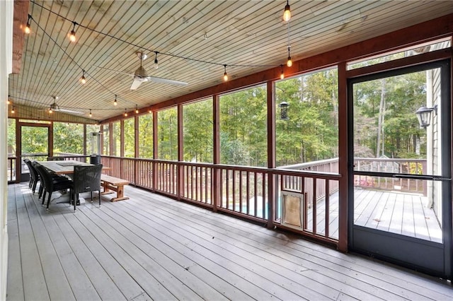 unfurnished sunroom featuring plenty of natural light, outdoor dining area, and ceiling fan