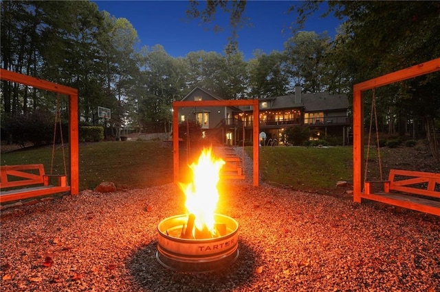 view of community featuring an outdoor fire pit and a yard