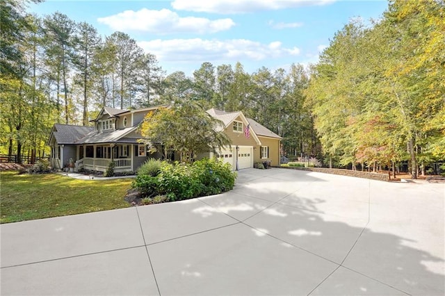 view of front of house with a front yard, covered porch, an attached garage, and concrete driveway