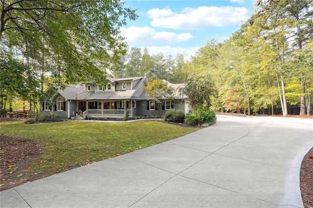 view of front facade featuring a front yard, covered porch, and concrete driveway
