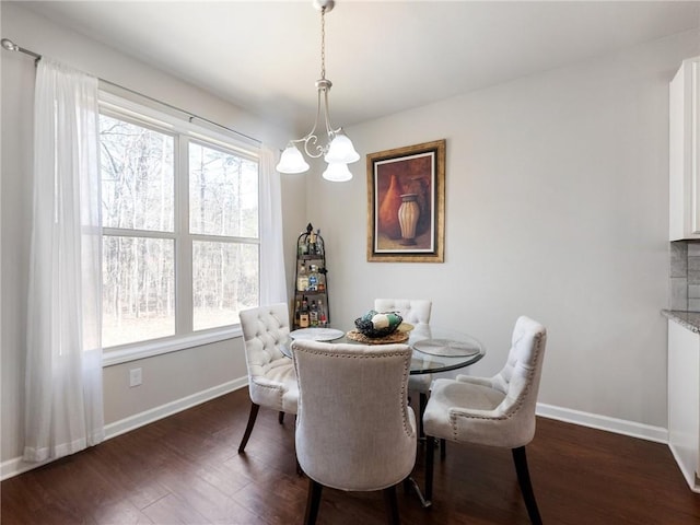 dining space featuring baseboards, a notable chandelier, and dark wood finished floors