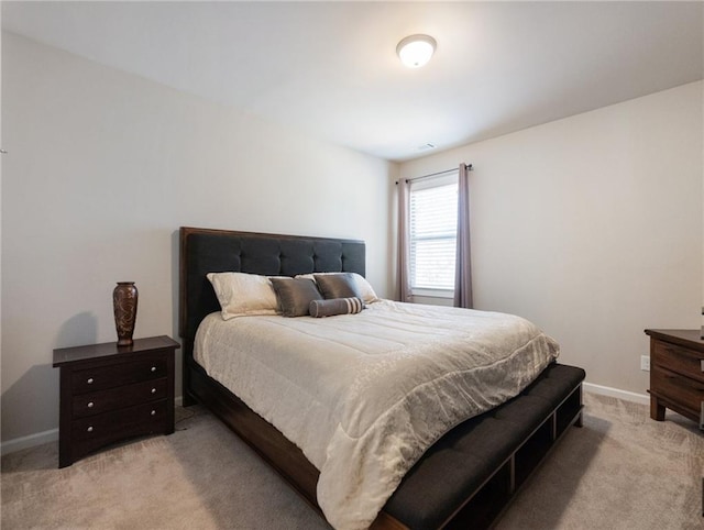 bedroom featuring baseboards and light carpet