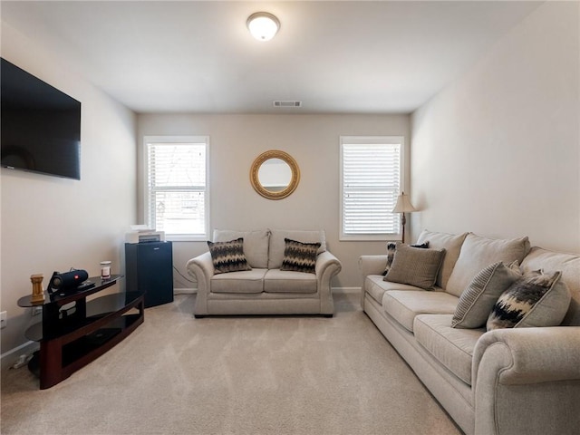 living room with visible vents, baseboards, and carpet