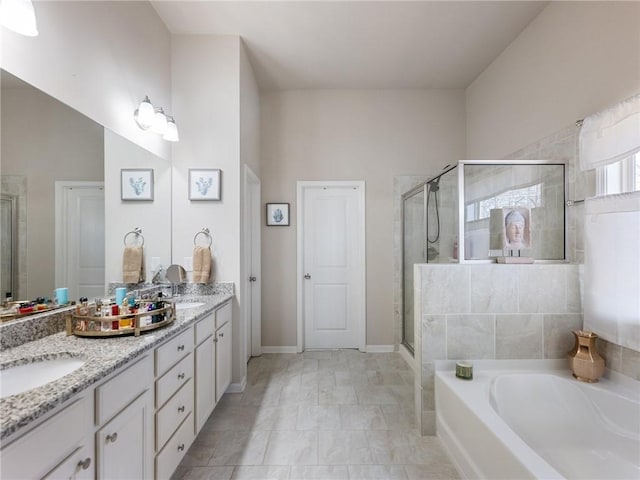 full bathroom featuring a bath, a stall shower, double vanity, and a sink