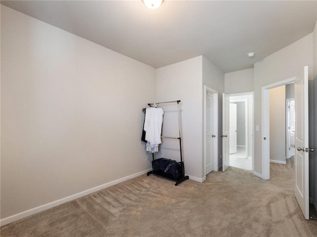 unfurnished bedroom featuring baseboards and light colored carpet