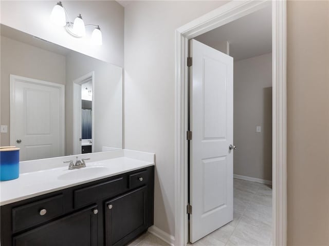 bathroom with tile patterned floors, vanity, and baseboards