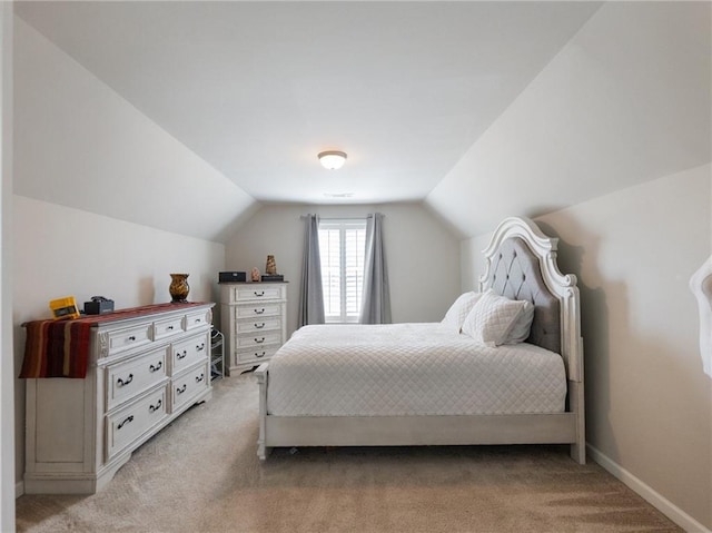 bedroom featuring light carpet, baseboards, and vaulted ceiling