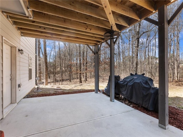 view of patio / terrace with a view of trees and grilling area