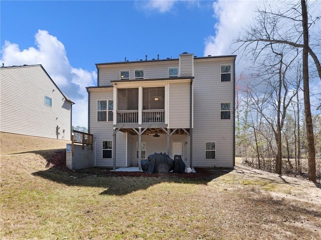 rear view of house featuring a yard, a patio area, and a sunroom