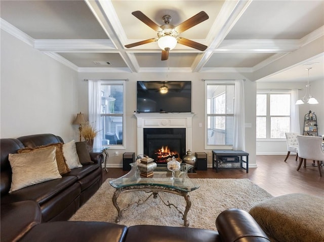 living area featuring beam ceiling, coffered ceiling, a warm lit fireplace, wood finished floors, and baseboards