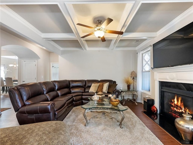 living room with beamed ceiling, a fireplace with flush hearth, coffered ceiling, dark wood finished floors, and arched walkways