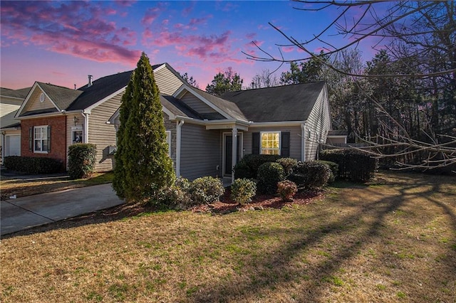 property exterior at dusk with driveway and a lawn