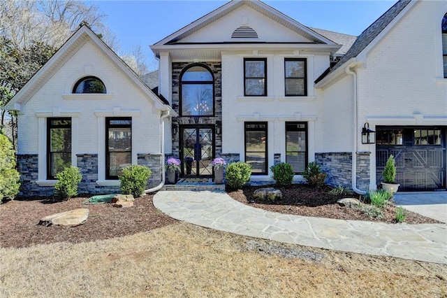 view of front of property with brick siding, driveway, and a garage