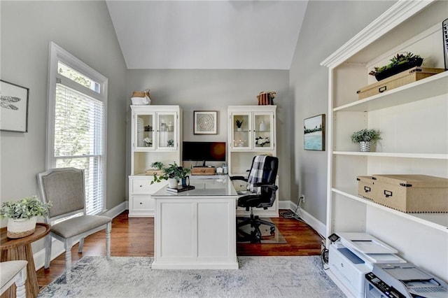 office featuring baseboards, lofted ceiling, and light wood-style flooring