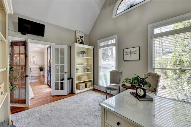 home office with plenty of natural light, french doors, high vaulted ceiling, and wood finished floors