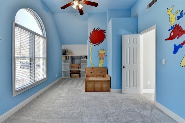 carpeted bedroom with lofted ceiling, baseboards, visible vents, and ceiling fan