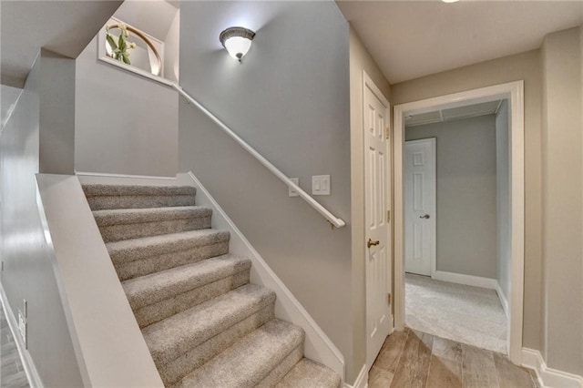 stairs with wood finished floors and baseboards