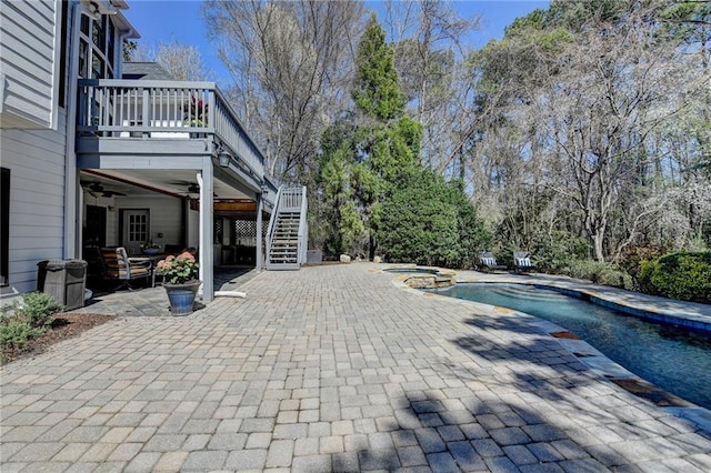 view of swimming pool with a pool with connected hot tub, ceiling fan, stairs, and a patio area