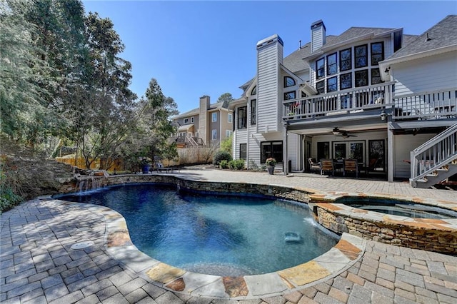 view of swimming pool with a patio area, stairway, a pool with connected hot tub, and a deck