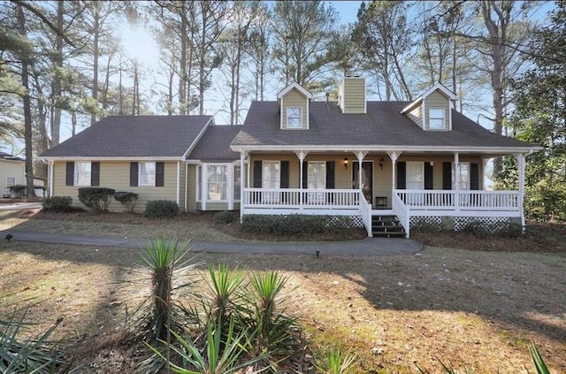 cape cod home featuring covered porch