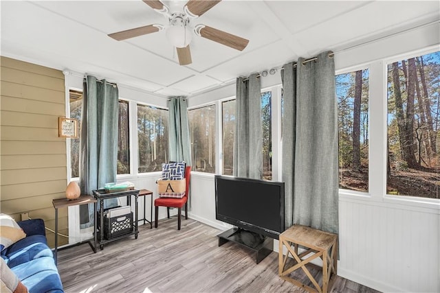 living room featuring light hardwood / wood-style flooring, ceiling fan, a fireplace, and a textured ceiling