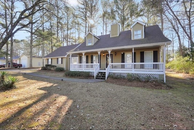 cape cod house with a garage and covered porch