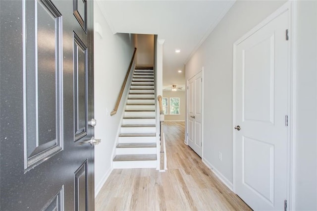 foyer with light wood-type flooring and ornamental molding