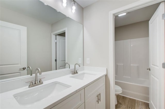 full bathroom featuring bathing tub / shower combination, hardwood / wood-style floors, vanity, and toilet