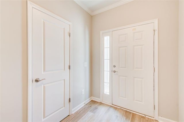 foyer featuring crown molding and light hardwood / wood-style flooring