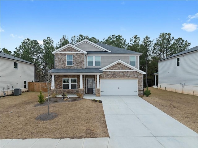 craftsman-style house with driveway, covered porch, a garage, stone siding, and central air condition unit