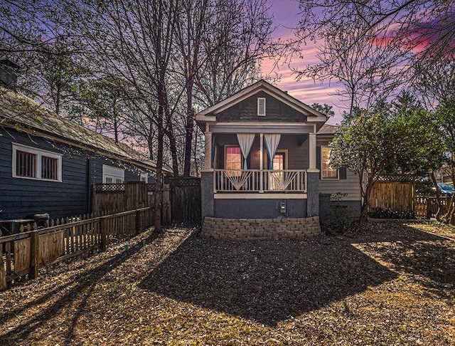 view of front of house featuring covered porch and fence