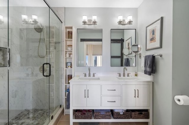 full bath with a sink, a marble finish shower, and double vanity