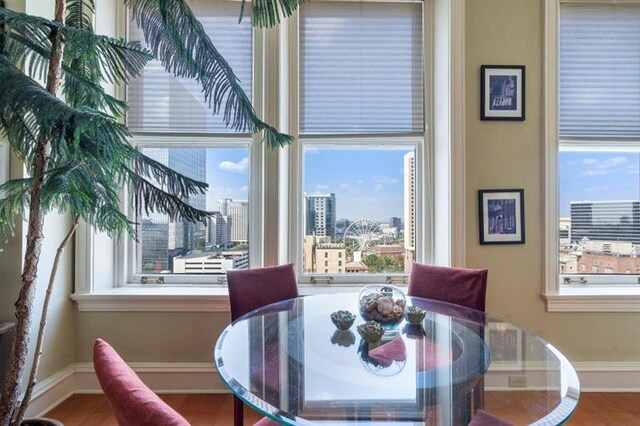 dining room with a view of city, baseboards, and wood finished floors