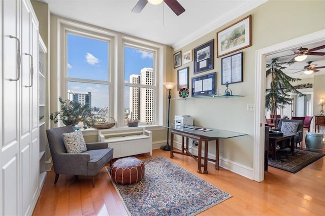 living area featuring ornamental molding, wood finished floors, a ceiling fan, and baseboards