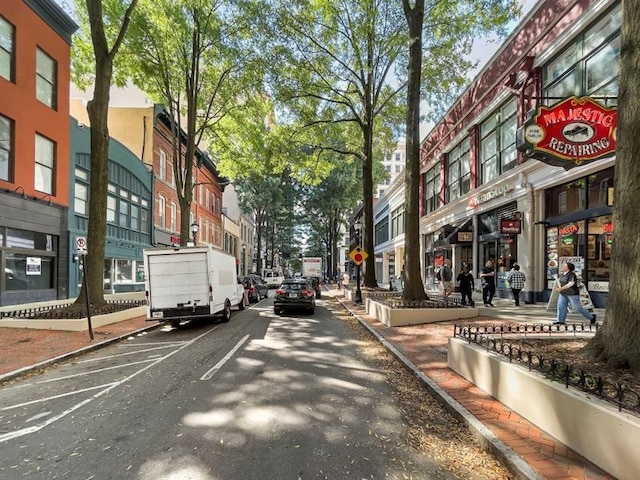 view of road with sidewalks, traffic signs, street lights, and curbs