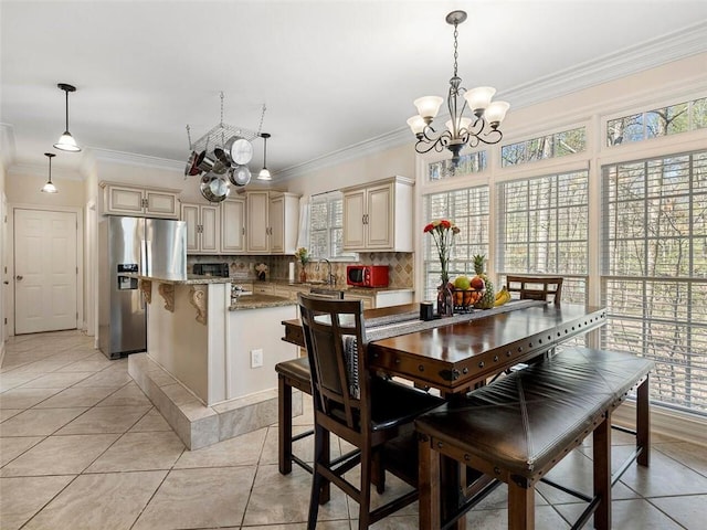 dining space featuring ornamental molding, a notable chandelier, sink, and light tile patterned floors