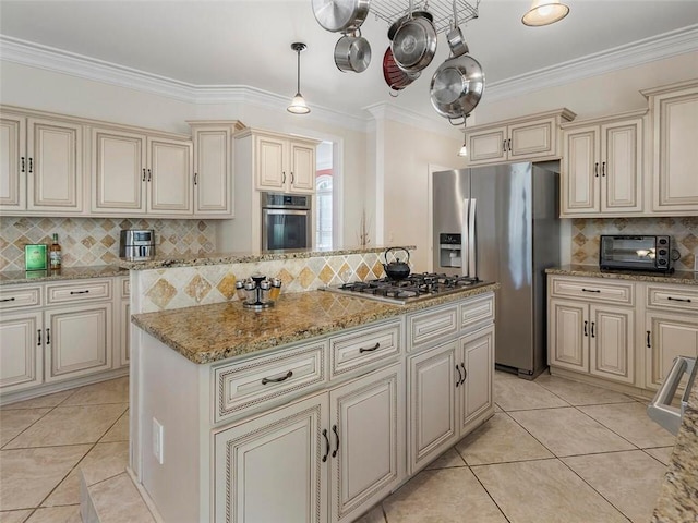 kitchen with cream cabinets, appliances with stainless steel finishes, and backsplash