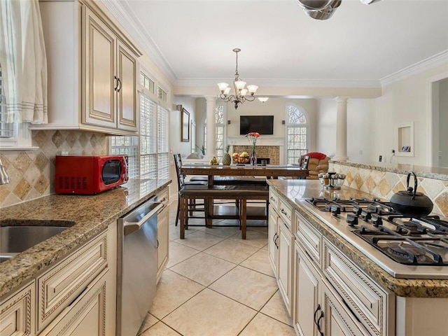 kitchen featuring ornate columns, crown molding, appliances with stainless steel finishes, and decorative backsplash