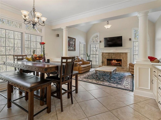 dining space featuring light tile patterned flooring, a brick fireplace, plenty of natural light, and a chandelier