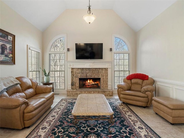 living room with a fireplace, high vaulted ceiling, and light tile patterned floors