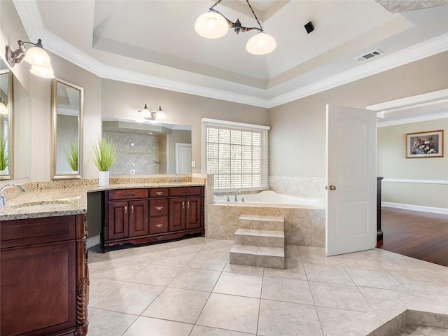 bathroom featuring wood-type flooring, vanity, a tray ceiling, and ornamental molding