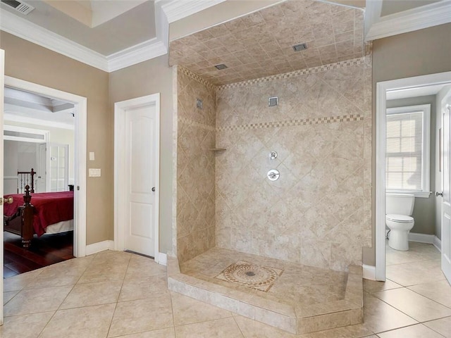 bathroom with tile patterned flooring, crown molding, tiled shower, and toilet