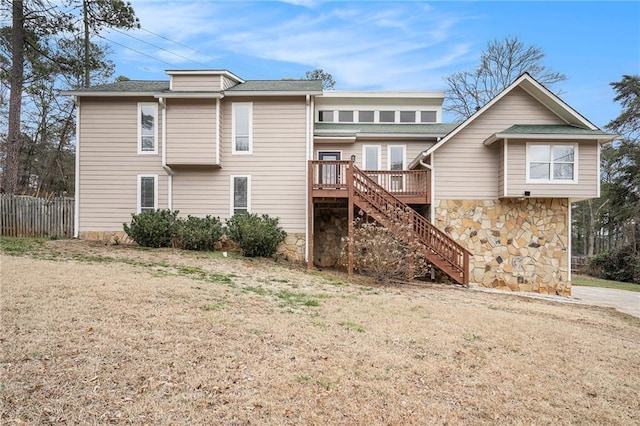 back of property with a wooden deck and a yard