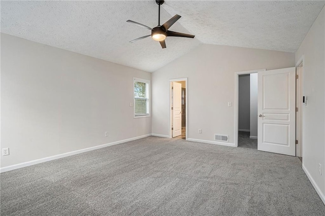 unfurnished bedroom with ceiling fan, lofted ceiling, carpet, and a textured ceiling