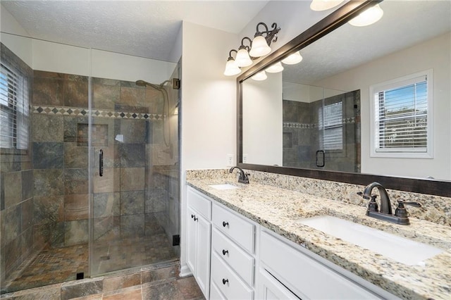 bathroom with vanity, a textured ceiling, and walk in shower