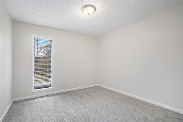 carpeted spare room with a textured ceiling