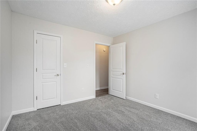 carpeted empty room with a textured ceiling