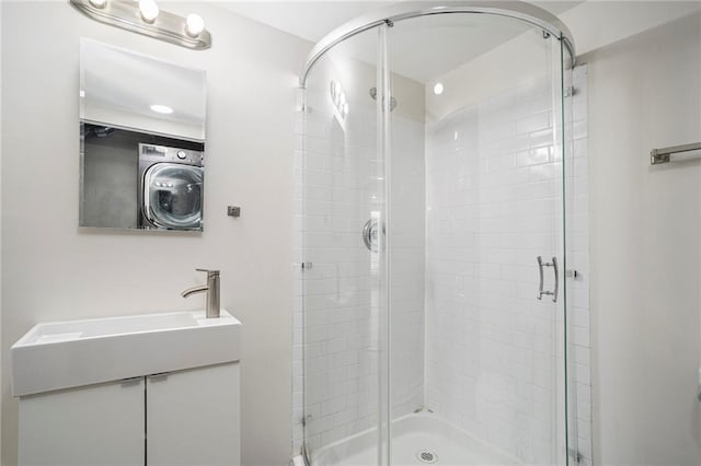 bathroom featuring vanity, washer / clothes dryer, and walk in shower