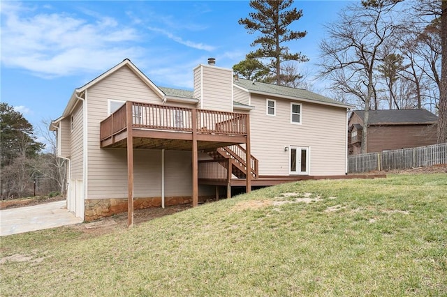 back of property featuring french doors, a deck, and a lawn